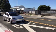 Tesla Model 3 rijdend in beeld