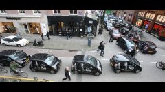 Colonne Toyota iQ door de Amsterdamse binnenstad