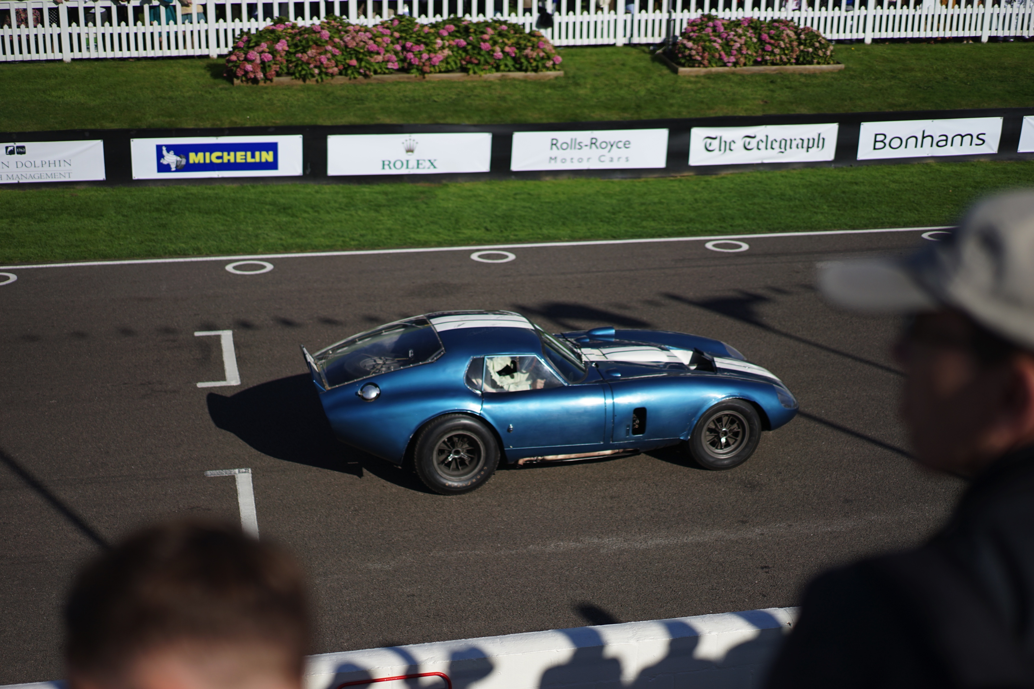 Zes Shelby Daytonas jagen over het legendarische Goodwood Motor Circuit. Het is de eerste keer dat ze allemaal bij elkaar zijn. Even later crasht de zeer kostbare Ferrari 250 GT breadvan...