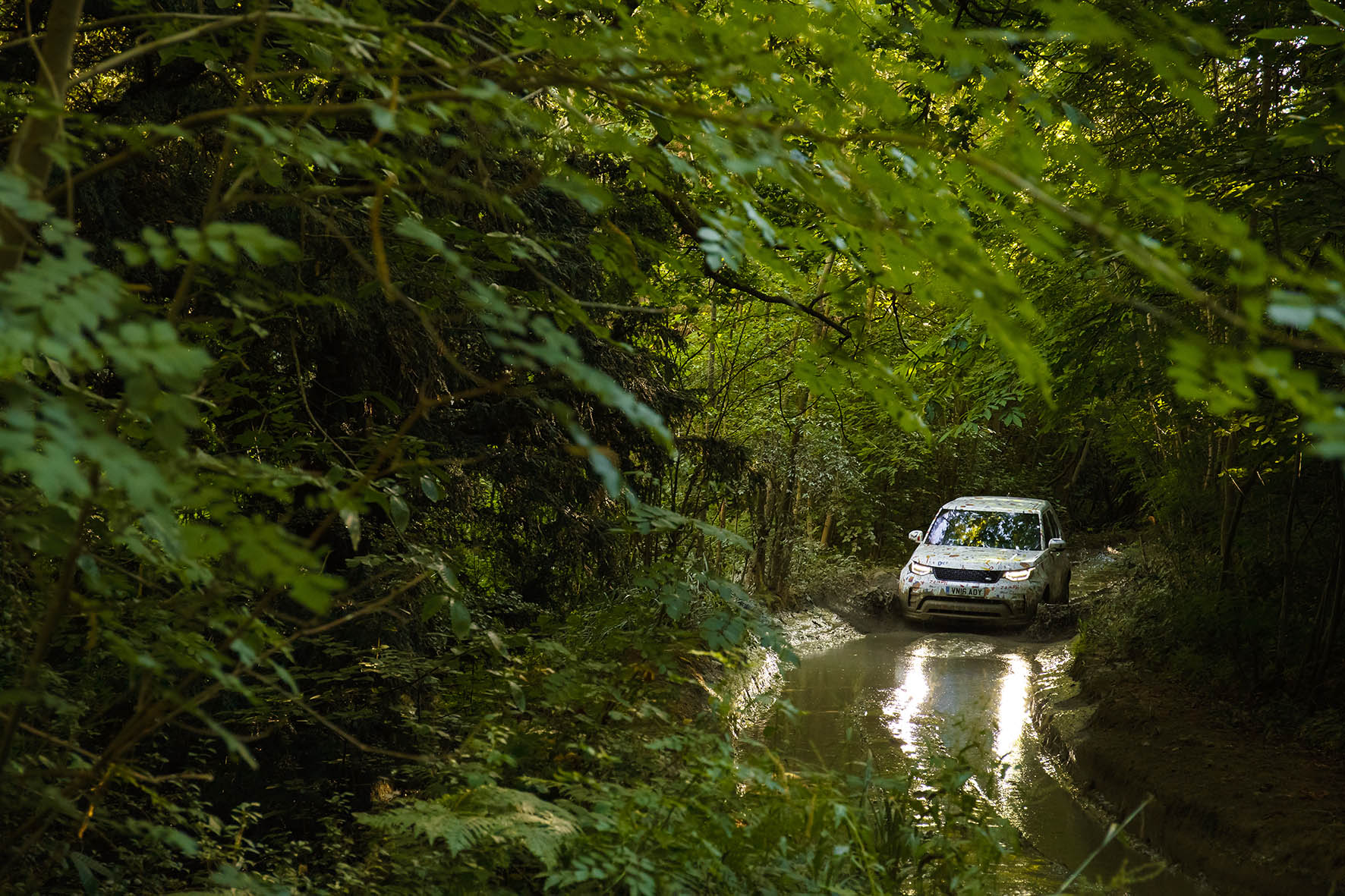 De nieuwe Land Rover Discovery laat zijn voorkant door dunne camouflage heen zien. Hij wijkt iets af van de eerder onthulde voorkant. Was dat dan een sportversie?