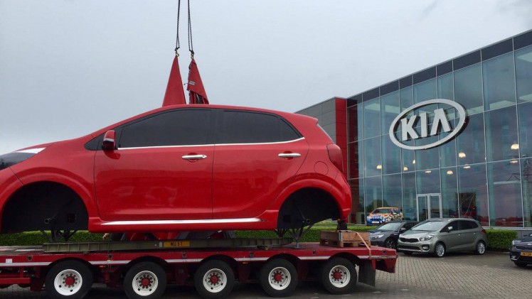 Na zes jaar een immense Kia Picanto in oranje voor de deur gehad te hebben heeft Kia deze reus vervangen door een rood exemplaar van de nieuwe generatie.