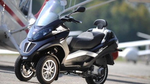 Een scooterachtige die rijdt als een motor en waarmee je gewoon met rijbewijs B de weg op komt. Deze bijzondere creatie is de Piaggio MP3 LT. Bij de prijs a 7789 euro die een kleine stadsauto zou miss