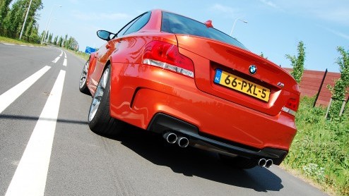 Hij is bloedstollend snel, rood-oranje en heerlijke sportief; de BMW 1 Serie M Coup. Onlangs logeerde het bommetje op de redactie en lieten coureur Danny van Dongen er even buiten mee spelen. Een ech