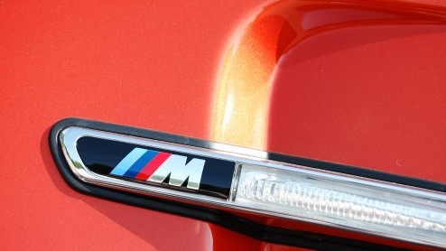 Hij is bloedstollend snel, rood-oranje en heerlijke sportief; de BMW 1 Serie M Coup. Onlangs logeerde het bommetje op de redactie en lieten coureur Danny van Dongen er even buiten mee spelen. Een ech