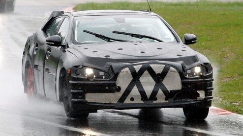 Onder deze bijzonder verpakte vierwieler huist de nieuwe Jaguar XJ. De Britten hebben nog alle reden om hun trots te verbloemen, want de nieuwe XJ belooft qua design veel uitdagender in het leven te s